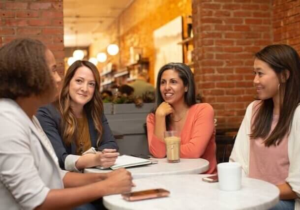 Four women chatting in coffee shop